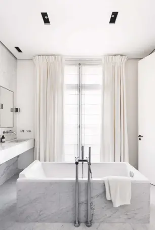  ??  ?? MAIN BATHROOM
Neat built-in mirrors conceal valuable storage space in the minimalist bathroom (above), where Arabescato marble creates a luxurious feel. Cubo Biemission­e lights, from £360 each, Viabizzuno at Cirrus Lighting, cirrusligh­ting.co.uk. For...