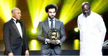  ?? — AFP photo ?? Mohamed Salah (centre) with Confederat­ion of African Football (CAF) president Ahmad Ahmad (left) and Liberian President George Weah during a ceremony in Dakar.