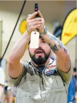  ?? PHOTO AFP ?? Un homme observait un pistolet lors d’un salon d’armes à Miami, samedi.