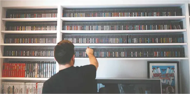  ?? PHOTOS GUILLAUME LEVASSEUR LE DEVOIR ?? Une collection de près de 700 cassettes de NES, classées en ordre alphabétiq­ue, couvre un mur du salon du passionné des jeux vidéo surnommé Papa cassette.