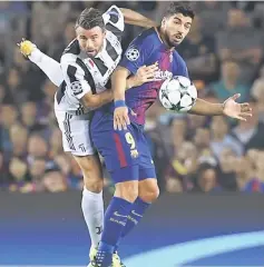  ??  ?? Juventus’ Andrea Barzagli (left) vies with Barcelona’s Luis Suarez during the UEFA Champions League Group D football match at the Camp Nou stadium in Barcelona. — AFP photo