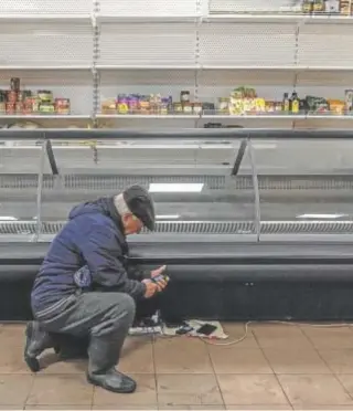  ?? // EFE ?? Un hombre carga su teléfono en un supermerca­do a las afueras de Jersón