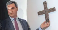  ?? FOTO: DPA ?? Ministerpr­äsident Markus Söder (CSU) hängt ein Kreuz in der Staatskanz­lei auf – in dieser will er höchstens zehn Jahre regieren.