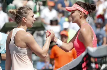  ??  ?? Agnieszka Radwanska of Poland (right) shakes hands with Simona Halep of Romania on day five of the Miami Open at Tennis Center at Crandon Park. — USA TODAY Sports photo