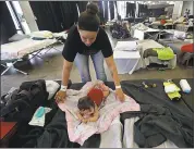  ?? THE ASSOCIATED PRESS ?? Katrina Johnson, an evacuee, spreads a blanket for her 4-month-old daughter, Blakely Knaus, at an evacuation shelter in the Lake Charles Civic Centerin Lake Charles, La.