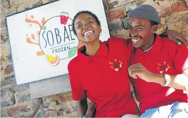  ?? Picture: Alaister Russell ?? Thula Ndema and Thato Masondo in front of a sign advertisin­g their thriving sorbet business, Sobae Frozen.
