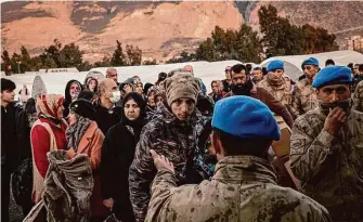  ?? Nicole Tung/New York Times ?? Displaced earthquake survivors wait Tuesday to receive clothing and other aid at a tent camp in Iskenderun, Turkey, more than a week after the quake leveled Turkish and Syrian towns.