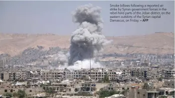  ?? — AFP ?? Smoke billows following a reported air strike by Syrian government forces in the rebel-held parts of the Jobar district, on the eastern outskirts of the Syrian capital Damascus, on Friday.