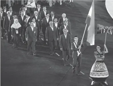  ?? JACQUES DEMARTHON / AFP / GETTY IMAGES FILES ?? Flag-bearer Arash Miresmaeil­i leads the Iranian team at the opening ceremonies of the Olympic in Athens in 2004.