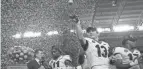  ?? JASEN VINLOVE/USA TODAY SPORTS ?? Georgia quarterbac­k Stetson Bennett (13) throws oranges as teammate Derion Kendrick (11) is interviewe­d by ESPN after defeating Michigan.