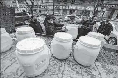  ?? [CHINATOPIX] ?? Workers unload canisters of disinfecta­nt from a truck in Wuhan in central China. Officials have reported that 132 are dead and more than 6,000 are ill on the mainland and abroad from the virus.