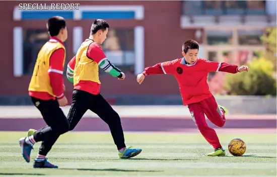  ??  ?? Students at the Hengchangd­ian Lane Primary School in Yuquan District of Hohhot play soccer during a physical education class on May 18, 2020.