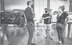  ?? JIM WEBER/SANTA FE NEW MEXICAN ?? Tesla owners Joshua Vigil and Melanie Vigil, right, talk with Tesla service manager Brandon Arpin at an event to celebrate the Nambe Pueblo deal.