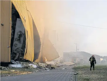  ?? REUTERS ?? A firefighte­r works at a site of a tobacco factory damaged during Russian suicide drone strike in Kyiv yesterday.