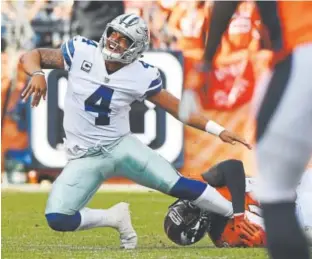  ??  ?? Shaquil Barrett, right, of the Broncos knocks down Dak Prescott of the Dallas Cowboys as he lets go of a pass during the second quarter Sunday.