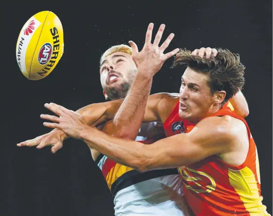  ??  ?? David Swallow (right) contests a ball with Geelong’s Rory Atkins, a key stat Suns coach Rodney Eade wants a repeat performanc­e of in China. Picture: JASON O’BRIEN