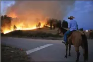  ?? (AP/Matthew Brown) ?? Rowdy Alexander watches Wednesday from atop his horse as a
hillside burns on the Northern Cheyenne Indian Reservatio­n near Lame Deer, Mont.