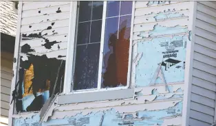  ?? GAVIN YOUNG ?? Saturday’s intense hailstorm shredded siding and shattered windows of homes and cars, as seen in Saddle Ridge in northeast Calgary on Monday.