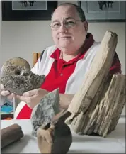  ?? Colleen De Neve, Calgary Herald ?? Fossils reveal mysteries of the past, says “Dino Dan” Quinsey, past president of the Alberta Palaeontol­ogical Society. With him are fossils of an ammonite (Placentice­ras meeki), a dinosaur bone, pine cone impression, a dinosaur vertebra and wood.