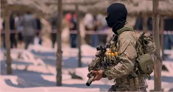  ?? GETTY ?? Un poliziotto tunisino controlla la spiaggia a Sousse durante la visita di funzionari del governo inglese