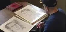  ?? CHRIS CAROLA/AP ?? World War II veteran Wilfred·Spike Mailloux looks through a series of sketches of U.S. Army soldiers while visiting the New York State Military Museum and Veterans Research Center in Saratoga Springs, N.Y. They were done in Hawaii by Stan Dube in 1943,...