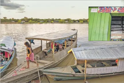  ??  ?? Comunidad. Una adolescent­e camina sobre un vetusta embarcació­n. Arriba, Un ‘prostibar’ en la Amazonía peruana, frontera con Colombia y Brasil.