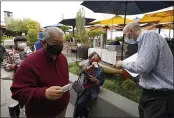  ?? ERIC RISBERG — THE ASSOCIATED PRESS FILE ?? Host Jason Pryor, right, checks the vaccinatio­n and identifica­tion cards of diners as they enter the Waterbar restaurant in San Francisco.