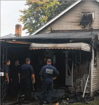  ?? RICK MCCRABB / STAFF ?? Middletown and Monroe fire investigat­ors are trying to determine the cause of a house fire in the 700 block of Elsmere Street on Wednesday morning. The house was vacant and there were no injuries, fire officials said. A neighbor used a garden hose to keep the fire from spreading to his home.