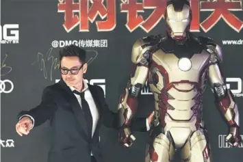  ??  ?? IRRELEVANT SCENES: Cast member Robert Downey Jr. poses for a photo with an Iron Man figure during a promotiona­l event of the movie “Iron Man 3” before its release in China at the Imperial Ancestral Temple of Beijing’s Forbidden City. — Reuters photo