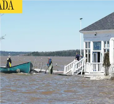  ?? PHOTOS: ANDREW VAUGHAN / THE CANADIAN PRESS ?? Sailors prepare to secure a work boat at the Royal Kennebecas­is Yacht Club in Saint John, N.B. on Saturday. Residents have been told it may be days, or even weeks, before water levels are below flood stage.