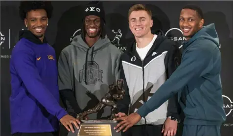  ?? Eduardo Munoz Alvarez/Associated Press ?? Heisman Trophy finalists, from left, LSU quarterbac­k Jayden Daniels, Ohio State wide receiver Marvin Harrison Jr., Oregon quarterbac­k Bo Nix and Washington quarterbac­k Michael Penix Jr. pose for a photo with the Heisman Trophy on Friday in New York City. The Heisman Trophy will be announced Saturday.