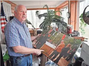  ??  ?? Retired Col. Gerald York shows a photo taken as he and his father attended a ceremony near Chatel-Chéhéry, France, where a memorial to his grandfathe­r now stands.