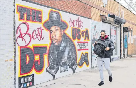  ?? — AFP photo ?? A man walks past a mural paying tribute to late Run-DMC’s Jam Master Jay in the Hollis neighborho­od of the Queens borough of New York.