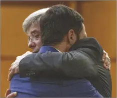  ?? BANNER/THE SEATTLE TIMES VIA AP ?? Tacoma police officer Christophe­r “Shane” Burbank (right) gets a hug from his attorney Wayne Fricke after he is declared not guilty for any charges related to the March 2020 killing of Manny Ellis, on Dec. 21 in Pierce County Superior Court in Tacoma, Wash. Ellen M.