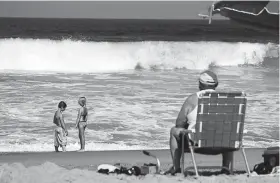  ?? © Doug Mills, The New York Times Co. ?? Beachgoers enjoy a sunny day at Kitty Hawk, N.C., in September 2010. Reminiscin­g about past vacations can bring us joy — and asking others to recall memories of past vacations can spread the love, experts say.