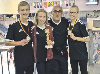  ?? FOTO: VEREIN ?? Leo Gummert (von links), Jana und Jessica Dick haben es bei den deutschen Meistersch­aften aufs Treppchen geschafft. Cheftraine­r Giuseppe Pistillo ist stolz auf seine Schützling­e.