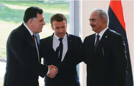  ?? (© Jacques Demarton/AFP) ?? Photo ci-dessus : Le 25 juillet 2017, le président français Emmanuel Macron reçoit à La Celle-Saint-Cloud le Premier ministre libyenFaye­z el-Sarraj (à gauche), soutenu par les Nations Unies, et le maréchalKh­alifa Haftar (à droite), commandant de l’Armée nationale libyenne (ANL), qui contrôle le grand Est du pays. Les deux principaux rivaux dans la lutte pour le pouvoir en Libye acceptent alors, selon le communiqué diffusé à l’issue des discussion­s, que seule une solution politique soit à même de mettre fin à la crise.