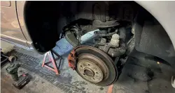  ?? ?? ABOVE: The seized brake caliper on the left side came off with no problem. It was rusted out from salty roads and old age, but the securing bolts were okay. Yes, Iain and Paul have an axle stand under the car and not just a trolley jack, because they like being alive.