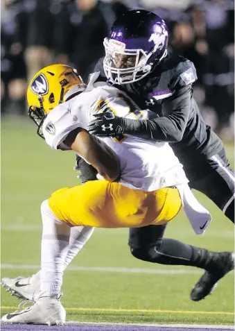  ?? MIKE HENSEN ?? Windsor Lancers’ Tristan Carter catches a touchdown in front of Bleska Kambamba of the Western Mustangs in a decisive 66-14 Mustangs victory Thursday night at TD Stadium in London.