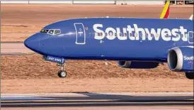  ?? Lola Gomez / The Dallas Morning News / Tribune News Service ?? A Southwest flight arrives in Dallas on Jan. 19. The company has reported revenue losses from fewer bookings following December’s meltdown.