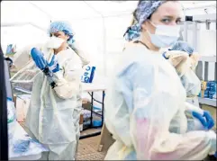  ??  ?? Upstanders: Medical workers don protective gear to treat COVIDstruc­k Gothamites at a field hospital set up by Samaritan’s Purse.