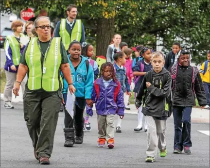  ?? KEVIN HOFFMAN — THE MERCURY ?? Edie Shean-Hammond, far left, leads a group of Rupert Elementary students as part of thewalking school bus onWednesda­y morning. Shean-Hammond is one of several adult volunteers who will walk children to school on safe, predetermi­ned routes.