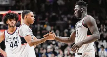  ?? Jessica Hill/Associated Press ?? Connecticu­t’s Jordan Hawkins and Adama Sanogo shake hands at the end of a game against Oklahoma State.