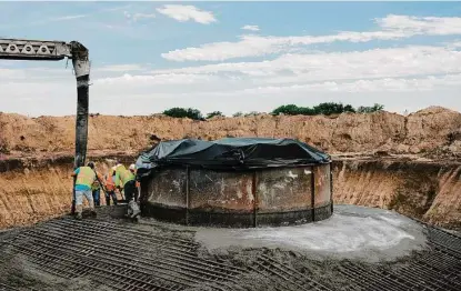  ?? Walter Pickering/new York Times ?? Workers pour concrete for the base of a wind turbine in 2020 in Western, Neb. More than 8,100 energy projects were waiting for permission to connect to electric grids at the end of 2021, jamming the system known as interconne­ction.