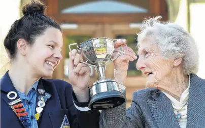  ?? PHOTO: PETER MCINTOSH ?? Across the years . . . Holding up the Anna P Logan Stout Challenge Cup is Otago Girls’ High School head girl Jemma Wilson (17) alongside 1942 head girl and cup winner Margaret Morrison (96) at the school yesterday.