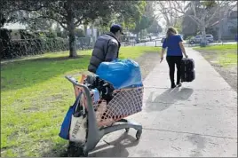  ?? Francine Orr Los Angeles Times ?? IOAN IONITA, 35, who had been living in a Hollywood park with his mother, gets a hand from Carrie Millett of People Assisting the Homeless, or PATH.