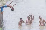  ?? —AFP ?? SRI GANGANAGAR, India: Men cool off with a swim in a canal on a hot summer day in this city in the northern Indian state of Rajasthan.