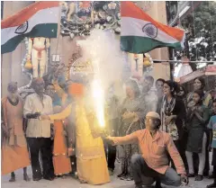  ?? —PTI ?? Mahant Dviyagiri of Mankameswe­r temple and people celebrate after army’s surgical strikes in Lucknow on Thursday.