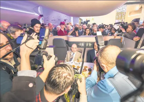  ?? Picture / Bloomberg ?? Akbar Al Baker demonstrat­es Qatar Airways’ new business- class seating to a mob of reporters at the Berlin travel expo.