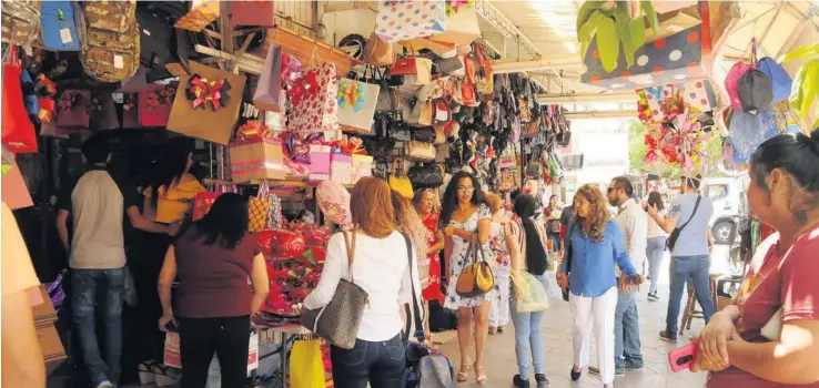  ?? JORGE COTA ?? > El centro de la ciudad lució abarrotado con las compras de último momento.